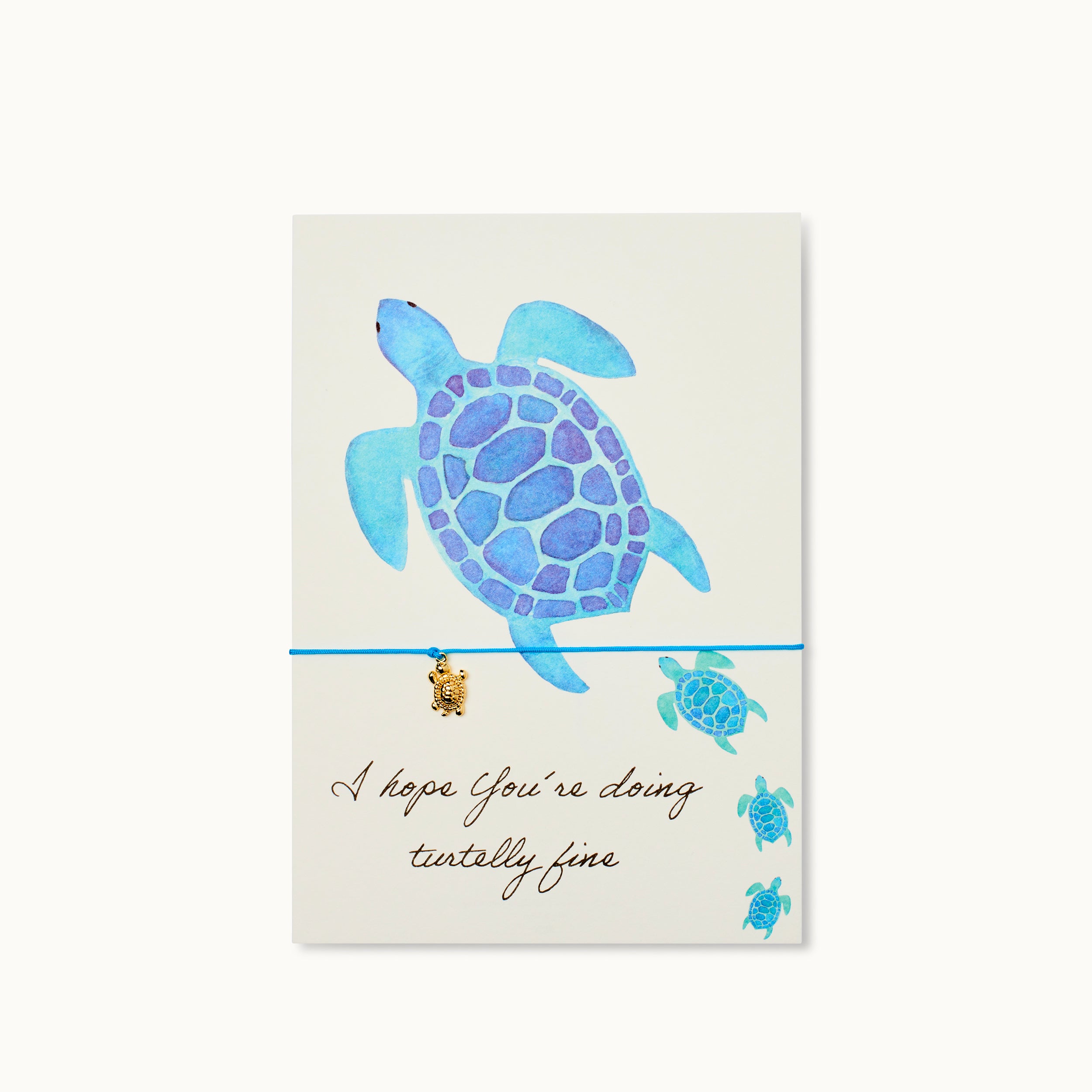Turtle Karte mit einer Schildkröte als 18K vergoldeter Anhänger an einem blauen Armband.    